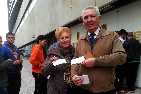 Una pareja de aficionados posan con los tickets de autobús para Algeciras / Trekant Media